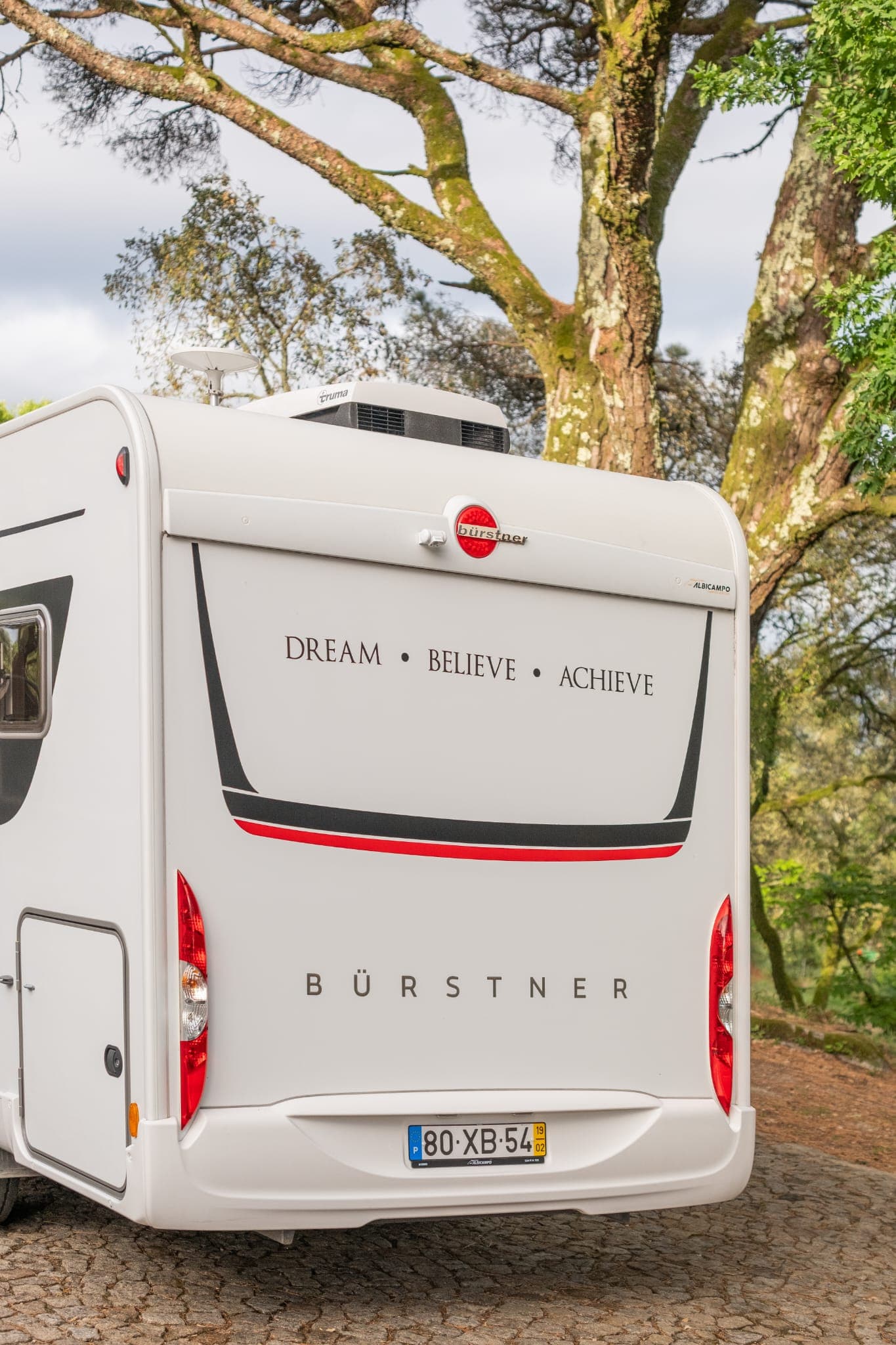 Traseira da autocaravana num caminho de floresta
